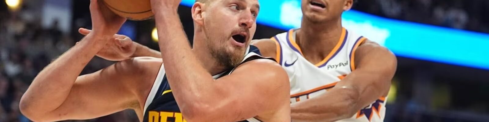 Нікола Йокіч Денвер Наггетс, підбирає м’яч під час матчу проти Фінікс Санз. Поруч — Осо Ігодаро.