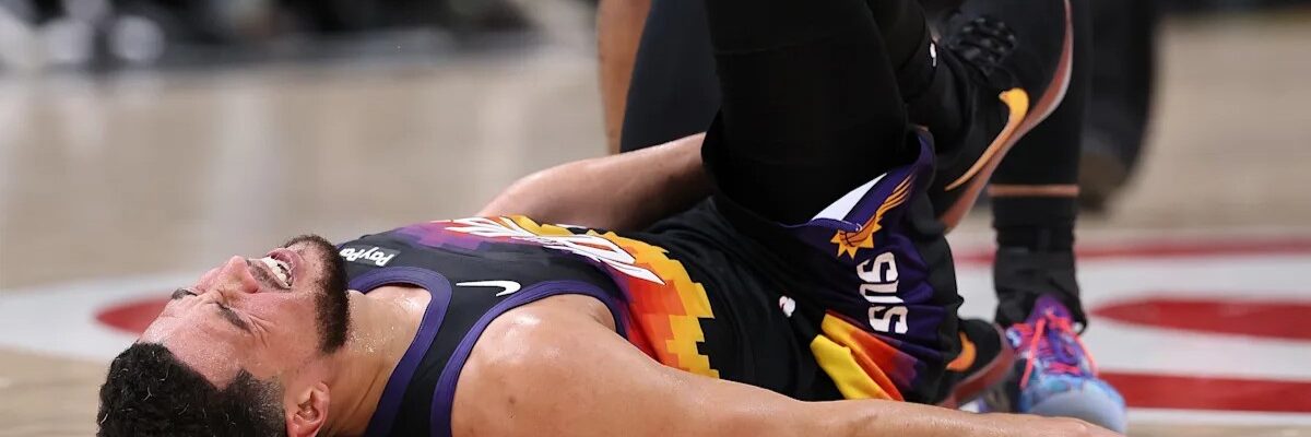 Девін Букер на паркеті після ушкодження правого гомілкостопа в матчі Фінікс Санз проти Атланта Гокс.